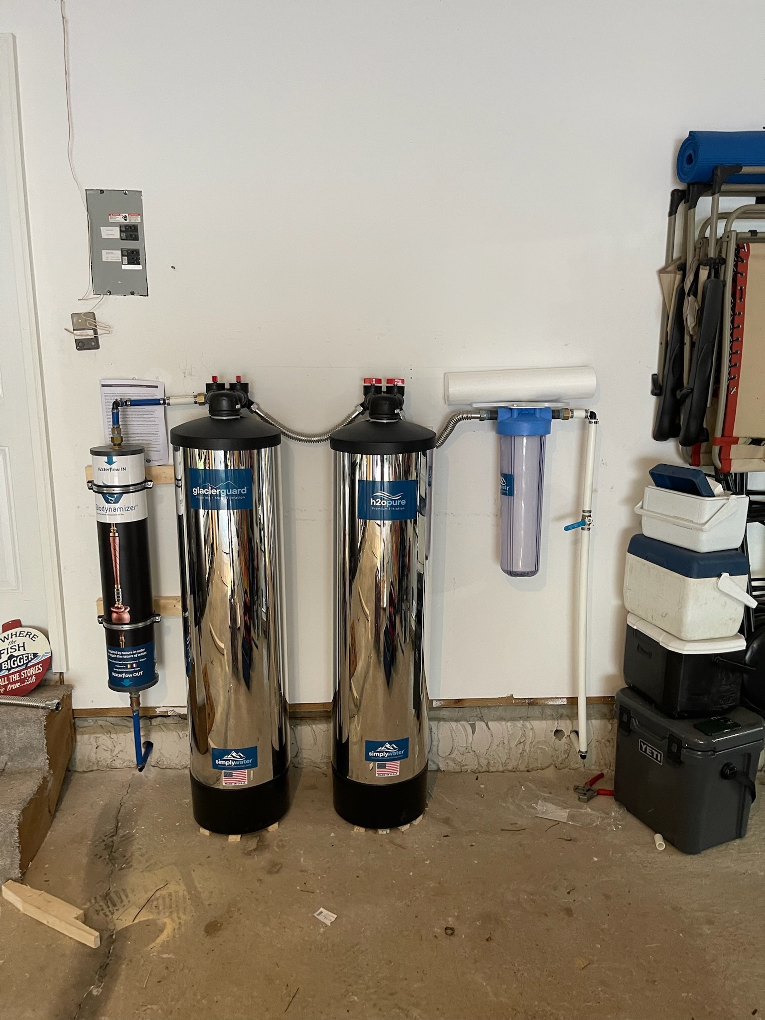 Simply Water tanks installed against a garage wall with tidy pipework