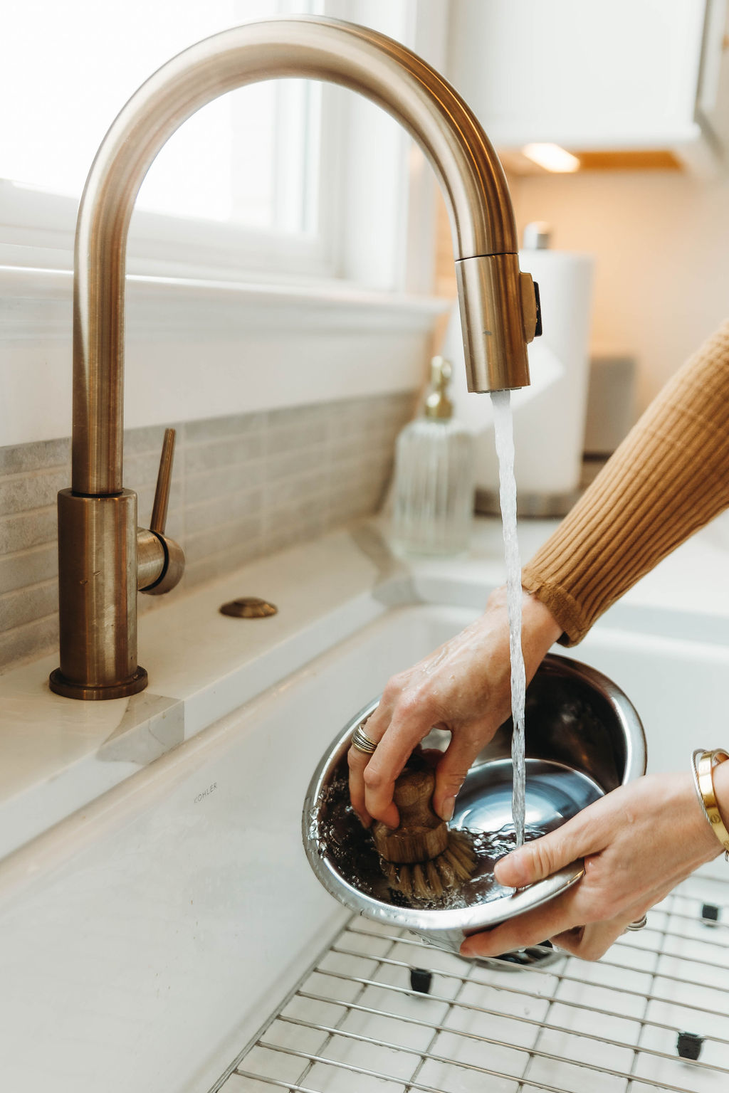 Hands rinsing produce under a kitchen faucet in a Middle Tennessee home