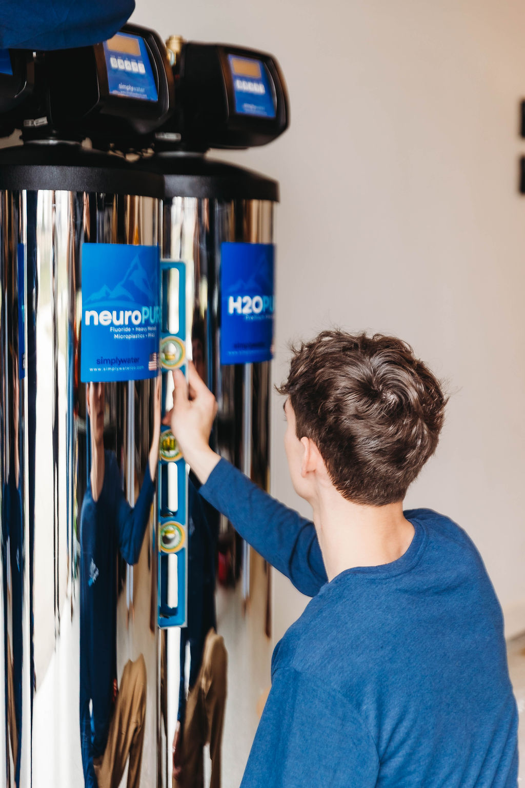 Technician mounting plumbing connections for a whole-home water treatment system